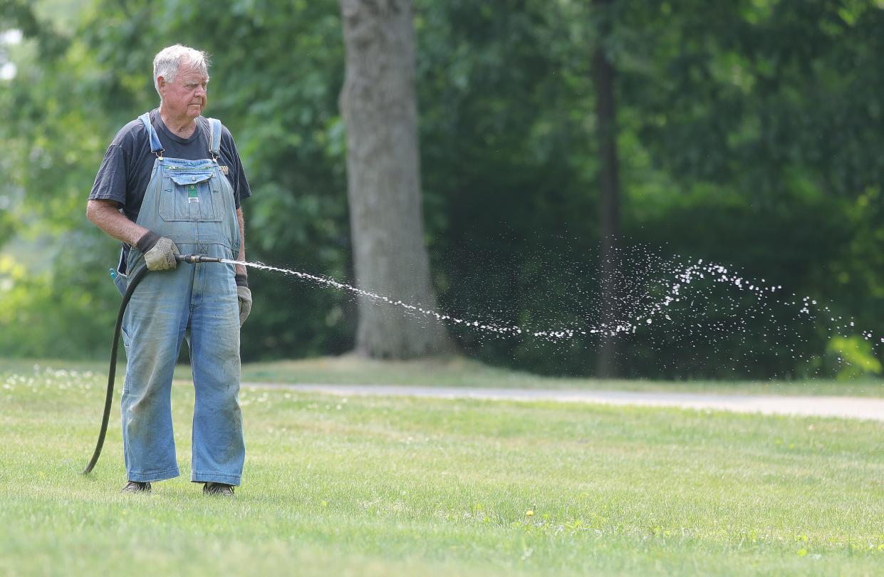 Bucky Stoltz waters a patch recently planted grass Tuesday at his Kellybrook Drive in Cuyahoga Falls.