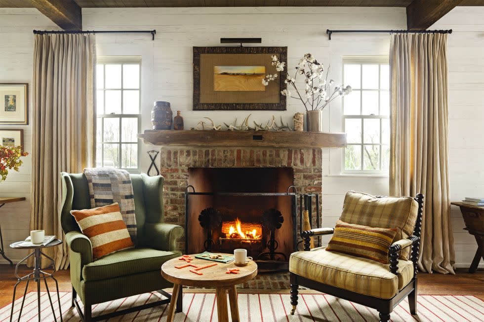 a pair of chairs in a cozy living room with a fire