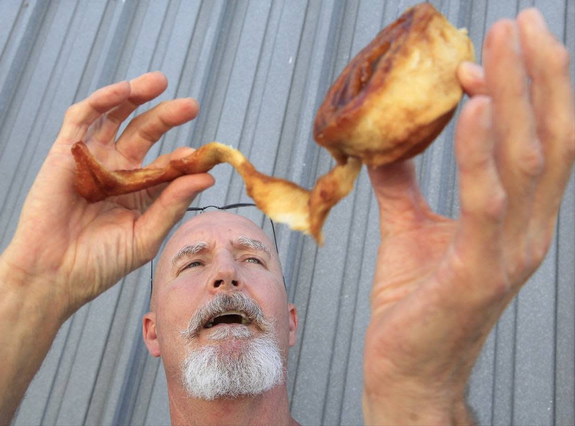 Thomas Blocher demonstrates the proper way to eat a cinnamon roll at Knaus Berry Farm in this file photo from Jan. 24, 2017. His favorite part he said on Feb. 23, 2023? The middle.