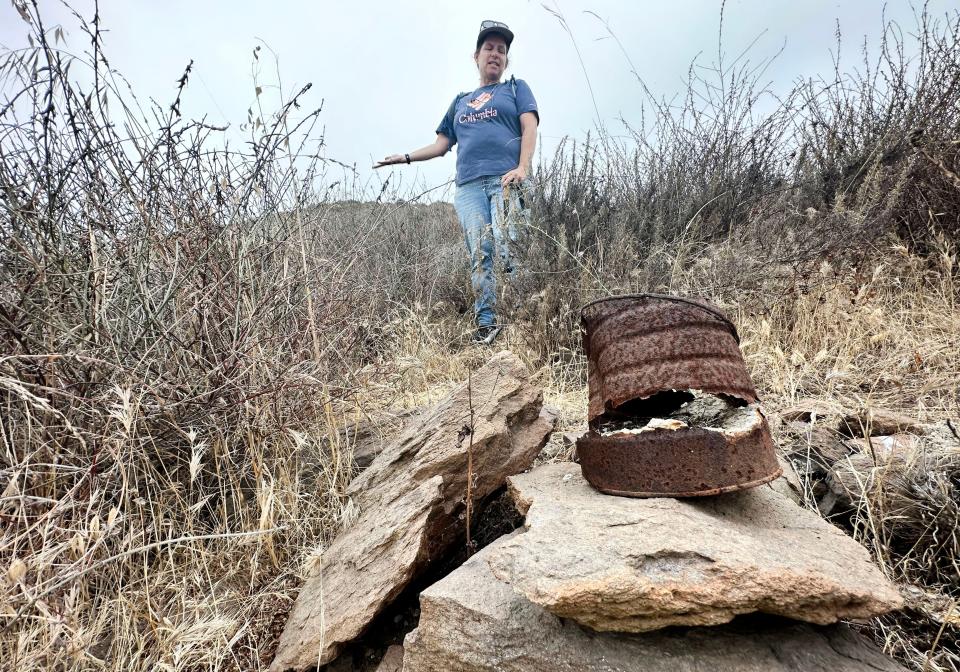 CSU Channel Islands professor Colleen Delaney looks at a rusted can found at a site she and her students excavated after the Springs Fire uncovered an old foundation near the Camarillo campus.