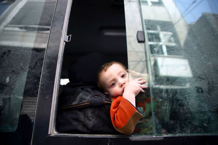 A child looks out of a bus window during evacuation from the besieged town of Douma, Eastern Ghouta, in Damascus, Syria March 19, 2018. REUTERS/Bassam Khabieh