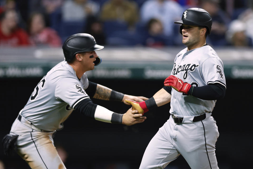 Chicago White Sox's Korey Lee, left, and Andrew Benintendi celebrate after scoring on a double by Dominic Fletcher off Cleveland Guardians pitcher Scott Barlow during the eighth inning of a baseball game Tuesday, April 9, 2024, in Cleveland. (AP Photo/Ron Schwane)