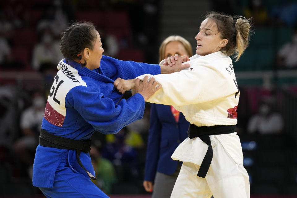 Urantsetseg Munkhbat of Mongolia, left, and Distria Krasniqi of Kosovo compete during their women's -48kg semifinal judo match at the 2020 Summer Olympics, Saturday, July 24, 2021, in Tokyo, Japan. (AP Photo/Vincent Thian)