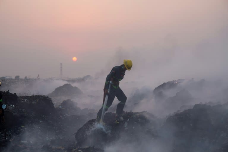 A fireman battles a huge fire at a massive garbage dump in Yangon