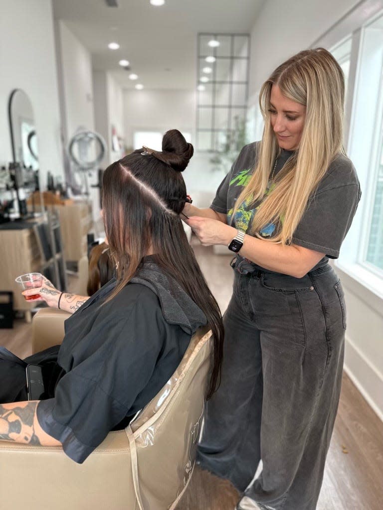 Renae Currey owner of Love Salons in Santa Rosa Beach, cuts a client's hair.