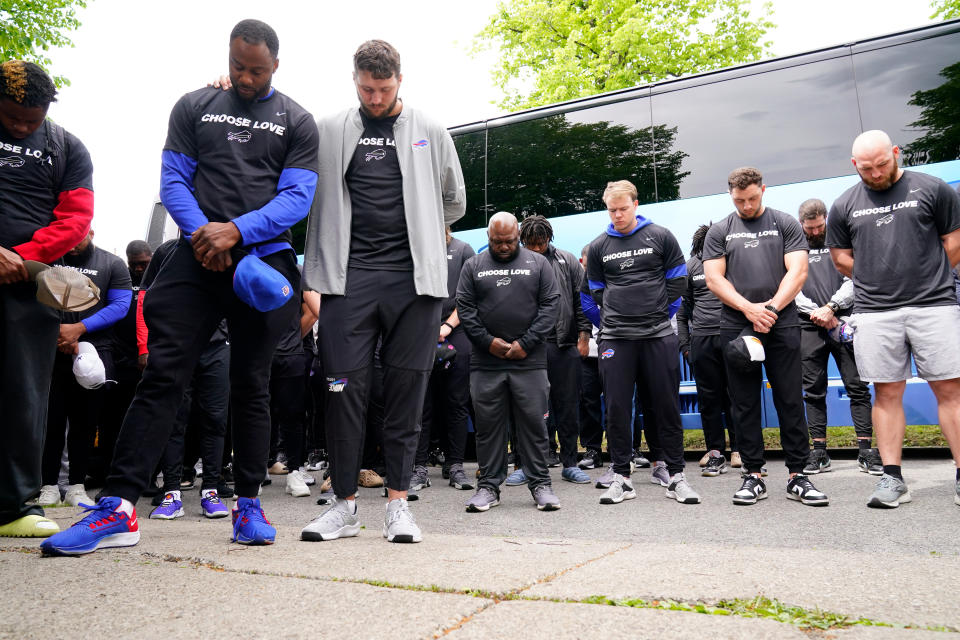 Members of the Buffalo Bills pray before visiting the scene of Saturday's shooting at a supermarket, in Buffalo, N.Y., Wednesday, May 18, 2022. (AP Photo/Matt Rourke)