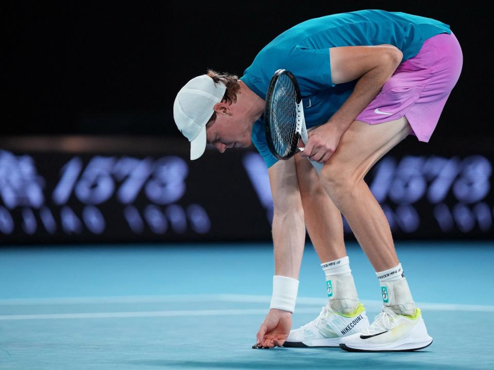 Jannik Sinner picks up a bug during the 2023 Australian Open.