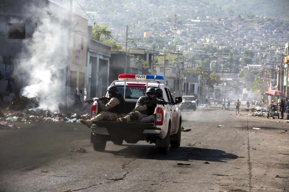 National Police patrol during a strike that is part of protests demanding to know how Petro Caribe funds have been used by the current and past administrations, in Port-au-Prince, Haiti, Monday, Nov. 19, 2018. Much of the financial support to help Haiti rebuild after the 2010 earthquake comes from Venezuela's Petro Caribe fund, a 2005 pact that gives suppliers below-market financing for oil and is under the control of the central government. (AP Photo/Dieu Nalio Chery)