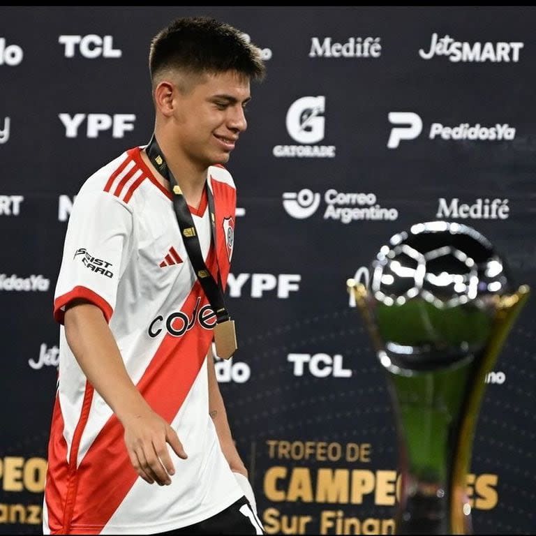 El Trofeo de Campeones en primer plano; detrás, Claudio Echeverri luce la medalla