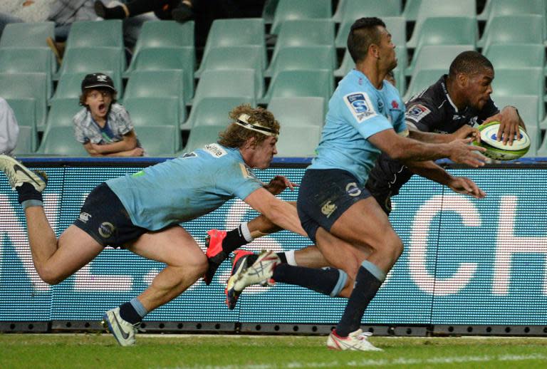 The NSW Waratahs' players Kurtley Beale (C) and Michael Hooper (L) fail to stop the Sharks' player Sibusiso Sithole from scoring a try, during their Super 15 rugby union match, at the Allianz Stadium in Sydney, on May 16, 2015