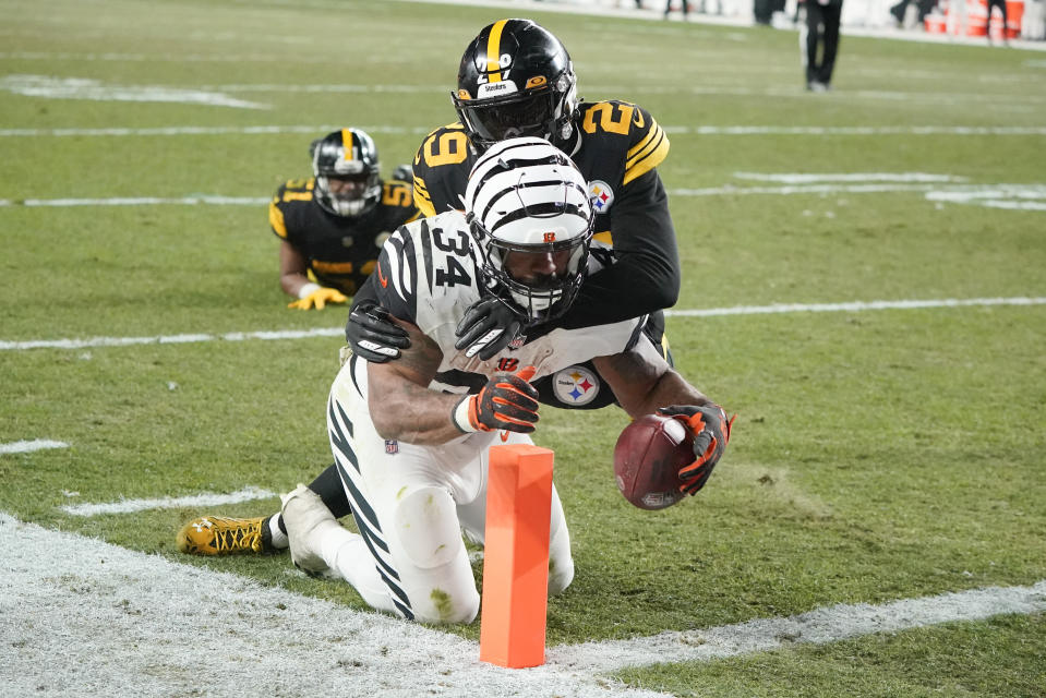 Cincinnati Bengals running back Samaje Perine (34) carries Pittsburgh Steelers cornerback Levi Wallace (29) on his way to a touchdown during the second half of an NFL football game, Sunday, Nov. 20, 2022, in Pittsburgh. (AP Photo/Gene J. Puskar)