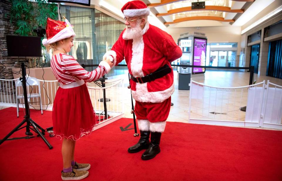 Madison Kidd, 8, of Graham, is greeted by Santa at the South Hill Mall in Puyallup, Washington, on Wednesday, Nov. 24, 2021.