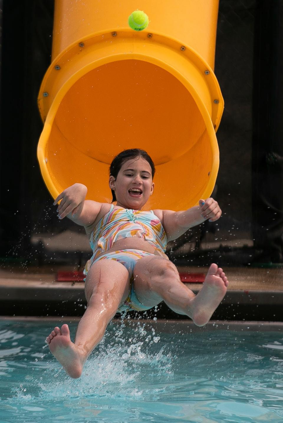 Natalie Furniss, 10 of Carroll, throws a tennis ball while playing a game of pass as she comes out of the water slide the the Bremen pool on June 5, 2023, in Bremen, Ohio.