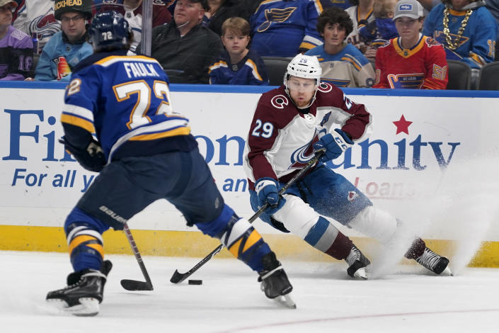 Colorado Avalanche's Nathan MacKinnon (29) handles the puck as St. Louis Blues' Justin Faulk (72) defends during the first period in Game 6 of an NHL hockey Stanley Cup second-round playoff series Friday, May 27, 2022, in St. Louis. (AP Photo/Jeff Roberson)