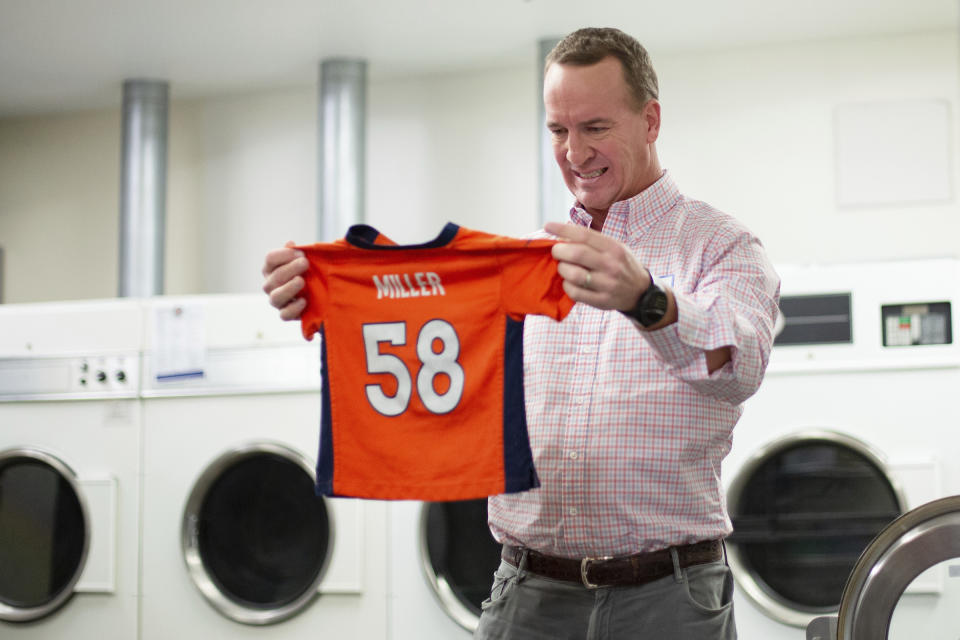 During filming for the Denver Broncos' 2021 schedule release video, former quarterback and current "intern" Peyton Peyton Manning washes a Von Miller jersey at UCHealth Training Center on Tuesday, May 10, 2021 in Englewood, Colo. Schedule release day has become a competition across the NFL between the social media departments of teams to see whose video creates the biggest impression. (Ben Swanson/Denver Broncos via AP)