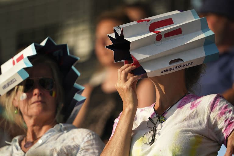 Aficionados belgas en las gradas se protegen del sol mientras esperan el inicio del partido de fútbol del grupo D de la Eurocopa 2022 Femenina entre Italia y Bélgica en el Manchester City Academy Stadium, en Manchester