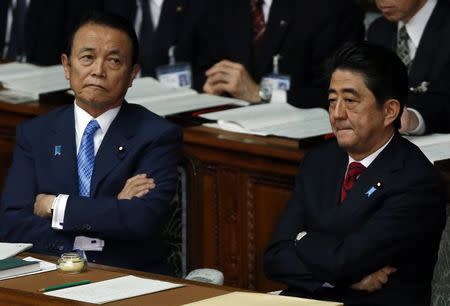 Japan's Prime Minister Shinzo Abe (R) and Japan's Deputy Prime Minister and Finance Minister Taro Aso sit at the lower house of the parliament in Tokyo, in this file picture taken January 24, 2014. REUTERS/Yuya Shino/Files