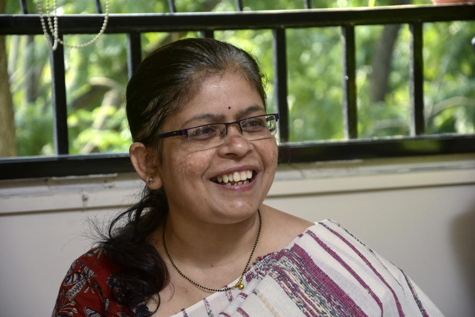 Manisha Shete, a practicing Hindu priest, smiles as she performs posthumous rituals for her client's mother at a residence in Pune, India, Wednesday, Oct. 20, 2021. Shete, who first began to officiate at religious ceremonies in 2008, said demand is growing and “people have started accepting women priests.” (AP Photo/Abhijit Bhatlekar)