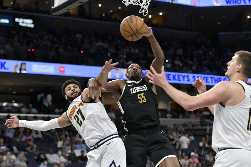 Memphis Grizzlies center Trey Jemison (55) shoots between Denver Nuggets guard Jamal Murray (27) and center Nikola Jokic, right, in the first half of an NBA basketball game Sunday, April 14, 2024, in Memphis, Tenn. (AP Photo/Brandon Dill)