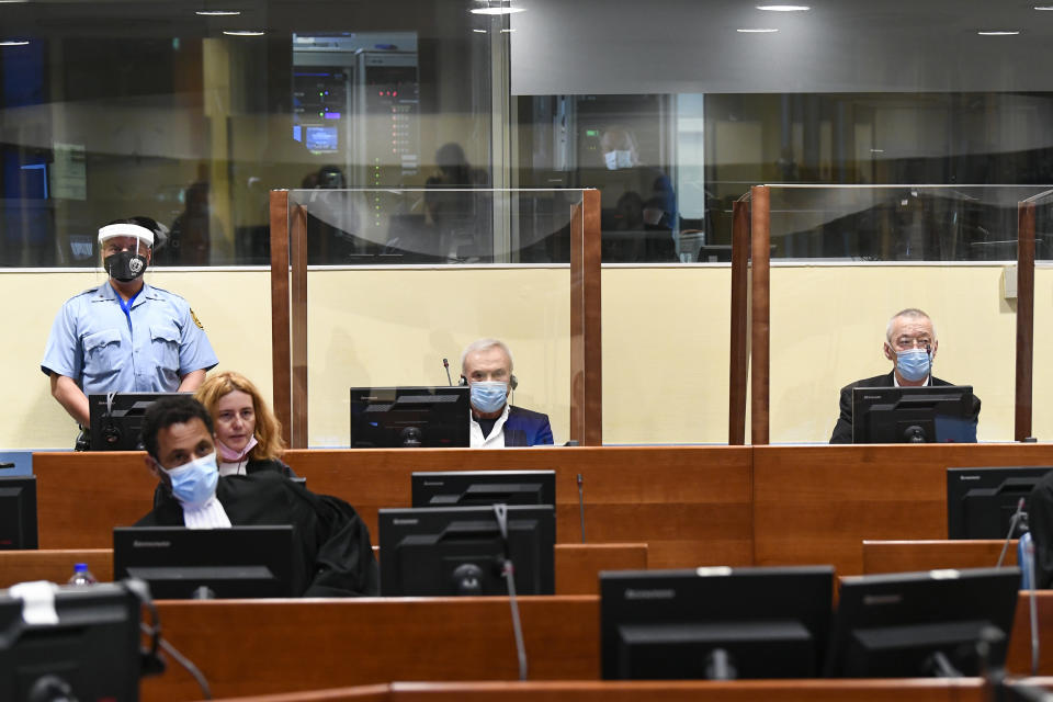 Former head of Serbia's state security service Jovica Stanisic, centre, and his subordinate Franko "Frenki" Simatovic, right, appear in court at the UN International Residual Mechanism for Criminal Tribunals (IRMCT) in The Hague, Netherlands, Wednesday June 30, 2021. A UN court is delivering judgments in the retrial of Jovica Stanisic and Franko Simatovic, accused of organizing, arming and supporting Serb paramilitaries that committed atrocities in Croatia and Bosnia as Yugoslavia crumbled in the early 1990s. (Piroschka van de Wouw/Pool via AP)