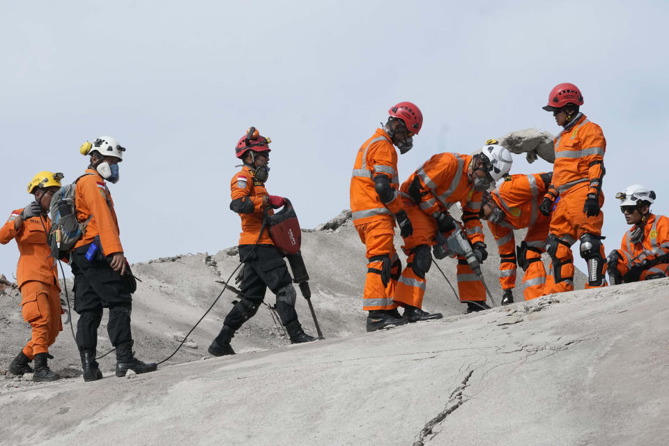 Rescuers use equipment to break through cement as they try to recover the body of an earthquake victim from under the rubble of a collapsed building in Cianjur, West Java, Indonesia,Tuesday, Nov. 22, 2022. Rescuers on Tuesday struggled to find more bodies from the rubble of homes and buildings toppled by an earthquake that killed a number of people and injured hundreds on Indonesia's main island of Java. (AP Photo/Tatan Syuflana)