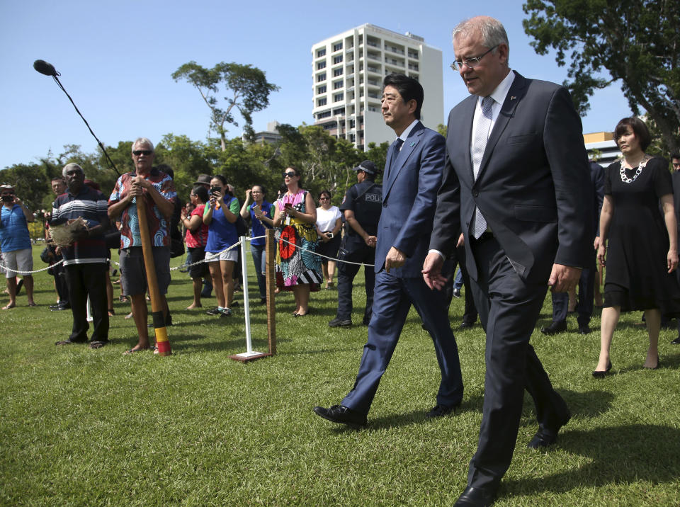 Japan's Prime Minister Shinzo Abe, center, walks with Australian Prime Minister Scott Morrison, center right, as they arrive at the Cenotaph War Memorial in Darwin, Friday, Nov. 16, 2018. Abe is on a two-day visit to Australia. At right is Abe's wife Akie Abe. (AP Photo/Rick Rycroft, Pool)