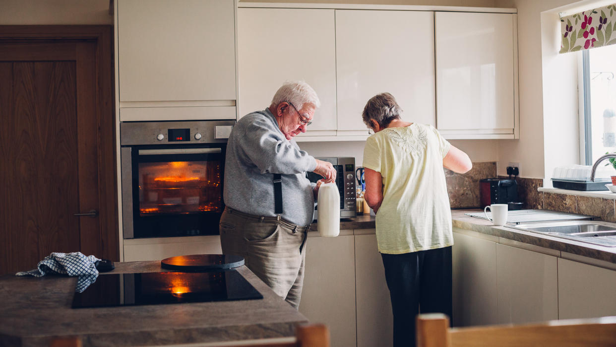 Elderly couple working in the kitchen together.