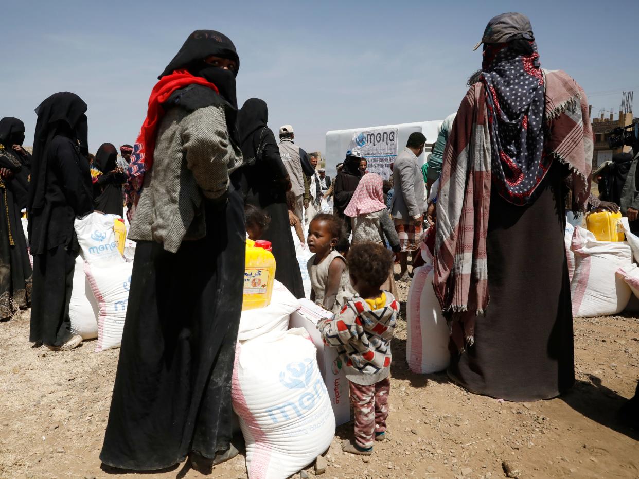 Yemenis are given food rations by the Mona Relief charity at a displaced persons camp in Sanaa (EPA)