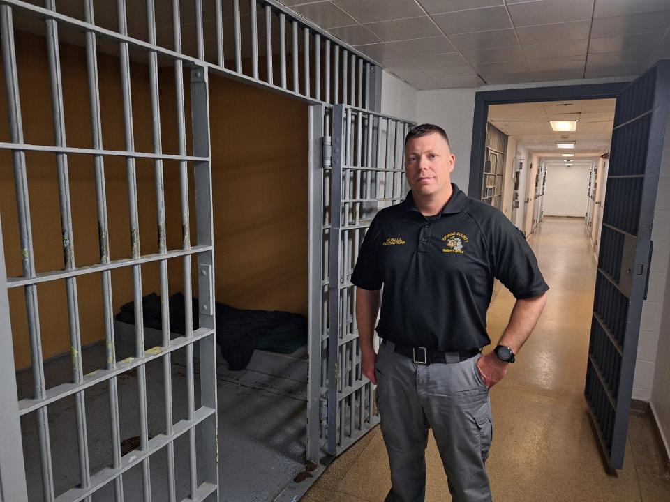 Scott Musall, the new administrator at the Otsego County Jail in Gaylord, stands next to the only holding cell in the facility that was built in 1967.