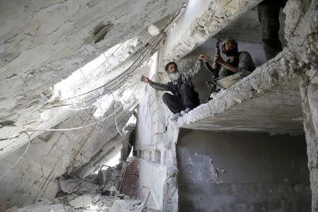 Rebel fighters from the Ahrar al-Sham Islamic Movement take positions inside a building in Jabal al-Arbaeen, which overlooks the northern town of Ariha, one of the last government strongholds in the Idlib province May 26, 2015. REUTERS/Khalil Ashawi