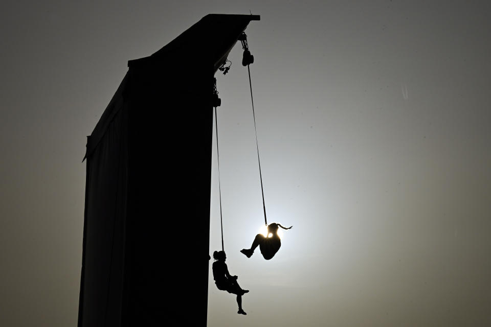 Silhouettes of climbers hanging on ropes after competing in the women's speed sport climbing qualification at the 2024 Olympic Qualifier Series held in Budapest, Hungary, Saturday, June 22, 2024. (AP Photo/Denes Erdos)