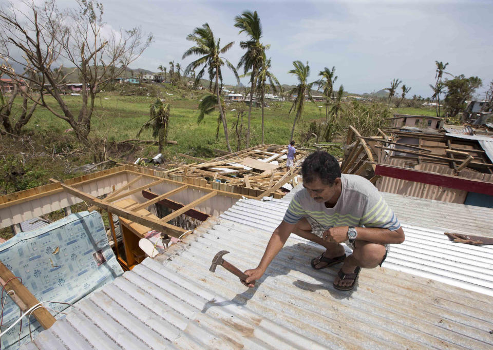 FILE - A man makes repairs to his home in RakiRaki, Fiji, Feb. 24, 2016, after Cyclone Winston ripped through the island nation. Many coastal communities in Fiji, were hard hit during Cyclone Winston in 2016, which led to the relocation of over 3,000 villagers from the coastal areas. (Brett Phibbs/New Zealand Herald via AP, File)