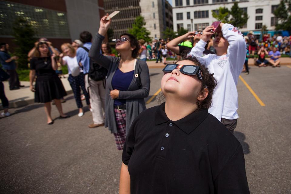 People gather to view the sun during a solar eclipse watch party Aug. 21, 2017, in downtown South Bend.