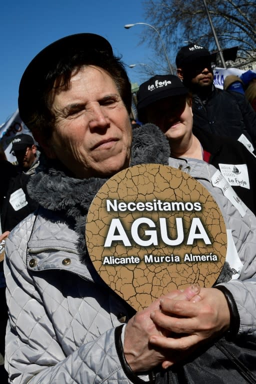 A woman holds a placard reading "We need water in Alicante, Murcia and Almeria" at a protest in Madrid by thousands of farmers from Spain's parched southeast