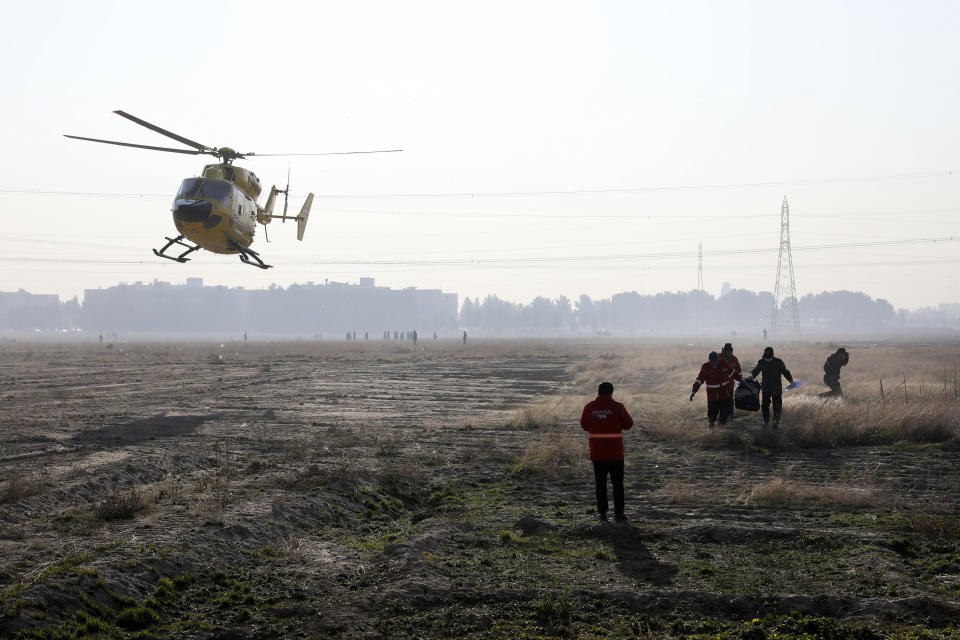 Rescue team work at the scene where an Ukrainian plane crashed in Shahedshahr, southwest of the capital Tehran, Iran, Wednesday, Jan. 8, 2020. A Ukrainian airplane carrying 176 people crashed on Wednesday shortly after takeoff from Tehran's main airport, killing all onboard. (AP Photo/Ebrahim Noroozi)