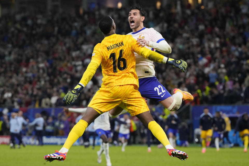 Theo Hernandez of France, right, celebrates with goalkeeper Mike Maignan after scores the winning goal to defeat Portugal during a quarterfinal match at the Euro 2024 soccer tournament in Hamburg, Germany, Friday, July 5, 2024. (AP Photo/Hassan Ammar)