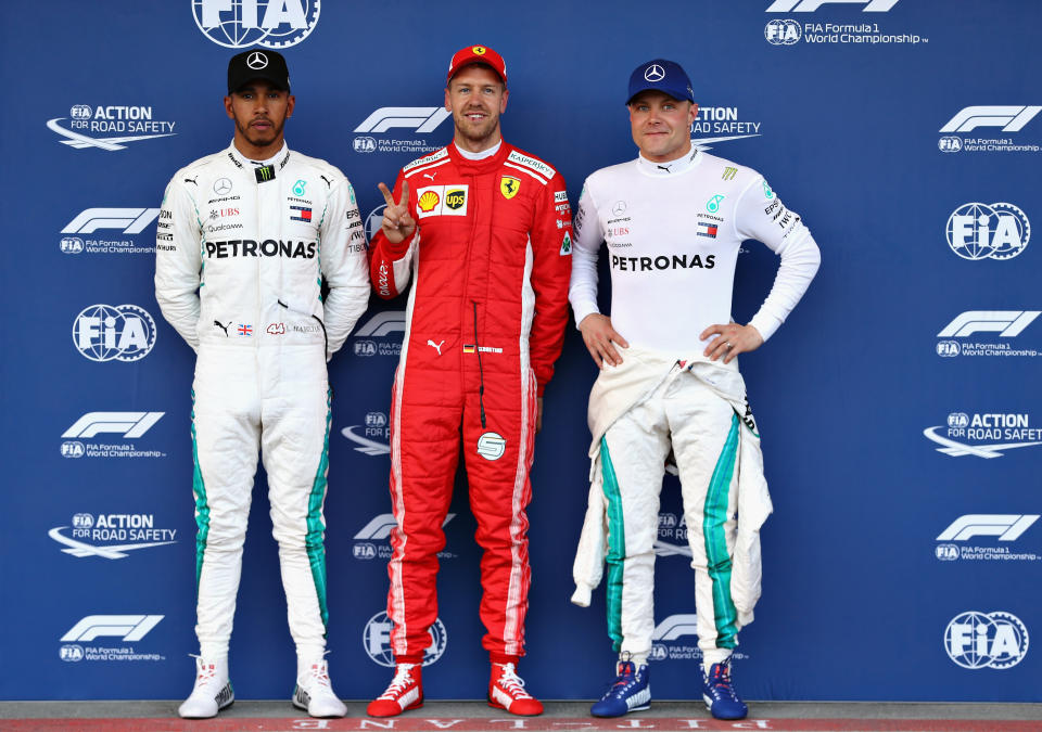 Sebastian Vettel of Germany and Ferrari, Lewis Hamilton of Great Britain and Mercedes GP and Valtteri Bottas of Finland and Mercedes GP celebrate their grid places