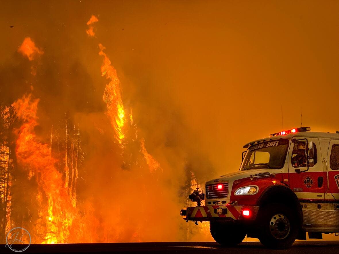 A firefighter surveys the Chuckegg Creek wildfire near High Level, Alta. in 2019. The fire burned more than 331,000 hectares, forcing residents of the town and nearby communities to leave their homes. (Josh Lambert - image credit)