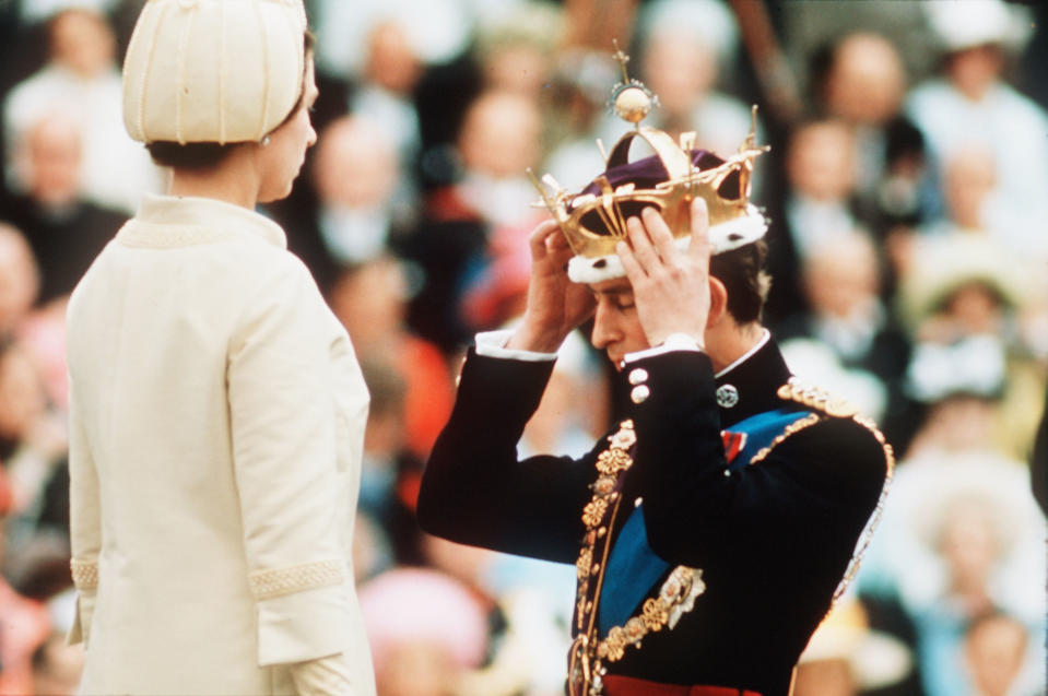 <p>The Queen places the gold coronet on her son Charles's head as he officially becomes the Prince of Wales at his investiture on 1 July 1969 at Caernarfon Castle. (Getty Images)</p> 