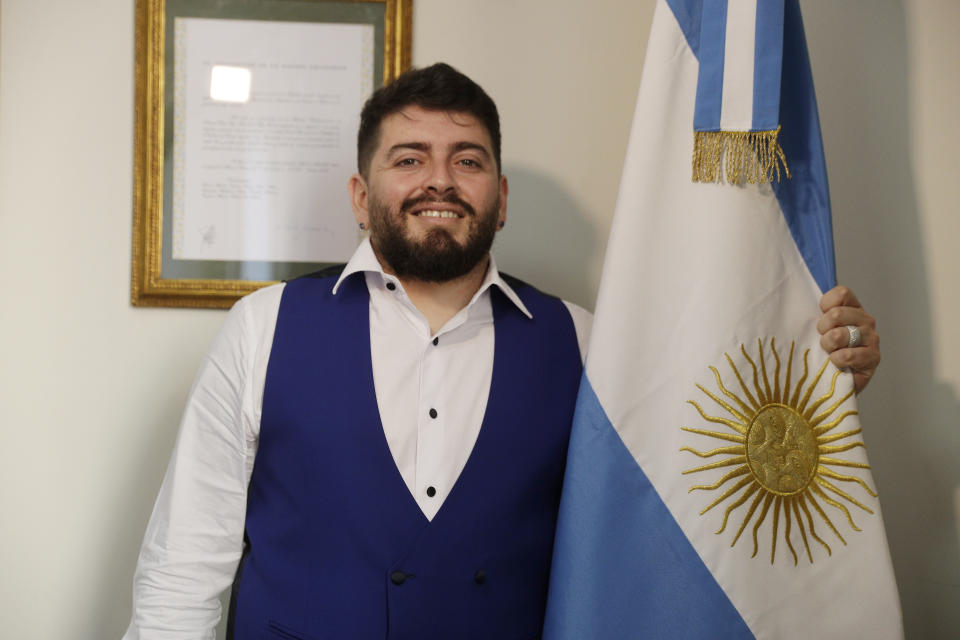 Diego Maradona Junior sujeta la bandera de Argentina al posar para una foto durante una entrevista con AP tras recibir la ciudadanía argentina en el consulado argentino en Roma, el jueves 25 de marzo de 2021. (AP Foto/Gregorio Borgia)