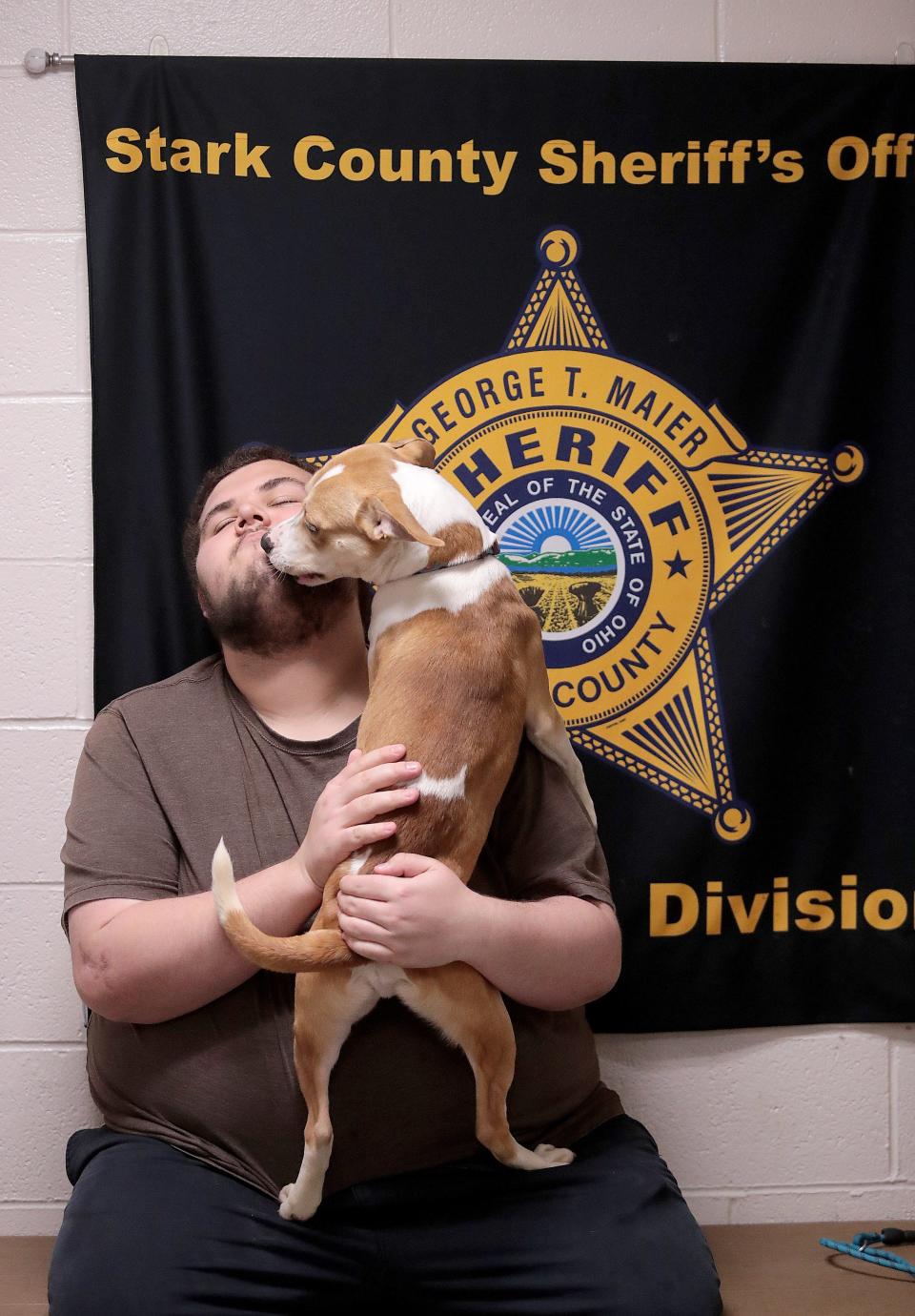 Stark County dog warden volunteer Andrew Miner gets kisses from Hollywood, a 1-year-old male that has been at the county facility since Nov. 22.