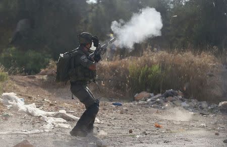 An Israeli border policeman fires a tear gas canister towards Palestinians during clashes following the funeral of Palestinian youth Laith al-Khaldi, in Jalazoun refugee camp near the West Bank city of Ramallah August 1, 2015. REUTERS/Mohamad Torokman