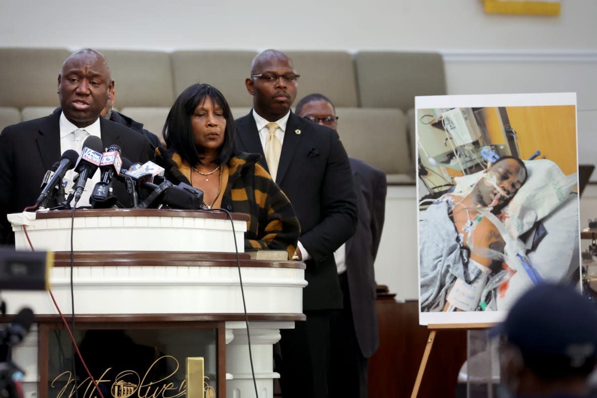 Flanked by Rodney Wells (C) and RowVaughn Wells, the stepfather and mother of Tyre Nichols, civil rights attorney Ben Crump speaks next to a photo of Nichols during a press conference on January 27, 2023 in Memphis, Tennessee. Tyre Nichols, a 29-year-old Black man, died three days after being severely beaten by five Memphis Police Department officers during a traffic stop on January 7, 2023. Memphis and cities across the country are bracing for potential unrest when the city releases video footage from the beating to the public later this evening. (Photo by Scott Olson/Getty Images)