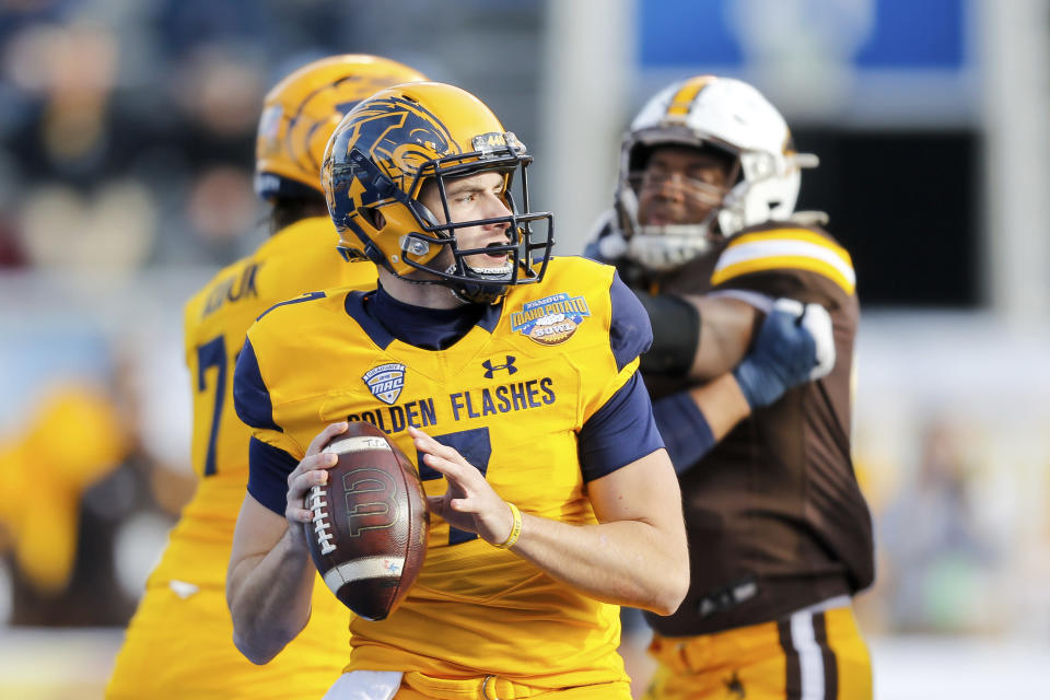 Kent State quarterback Dustin Crum (7) looks down field before throwing an 80 yard touchdown pass against Wyoming during the first half of the Idaho Potato Bowl NCAA college football game, Tuesday, Dec. 21, 2021, in Boise, Idaho. (AP Photo/Steve Conner)
