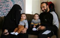 Mohamed Abdallah, his wife Merna Reda and their biological son Soliman, sit next to Dawood, an orphan they sponsor, in their home in Cairo