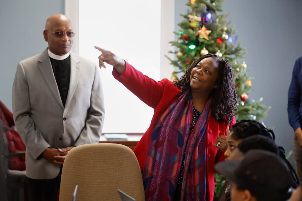 Geralde Gabeau, executive director of the Immigrant Family Services Institute in Boston, speaks with Haitian immigrants as Pastor Ray Hammond, left, looks on, Friday, Dec. 22, 2023, in a rectory building at the Bethel AME Church in the Jamaica Plain neighborhood of Boston. (AP Photo/Michael Dwyer)