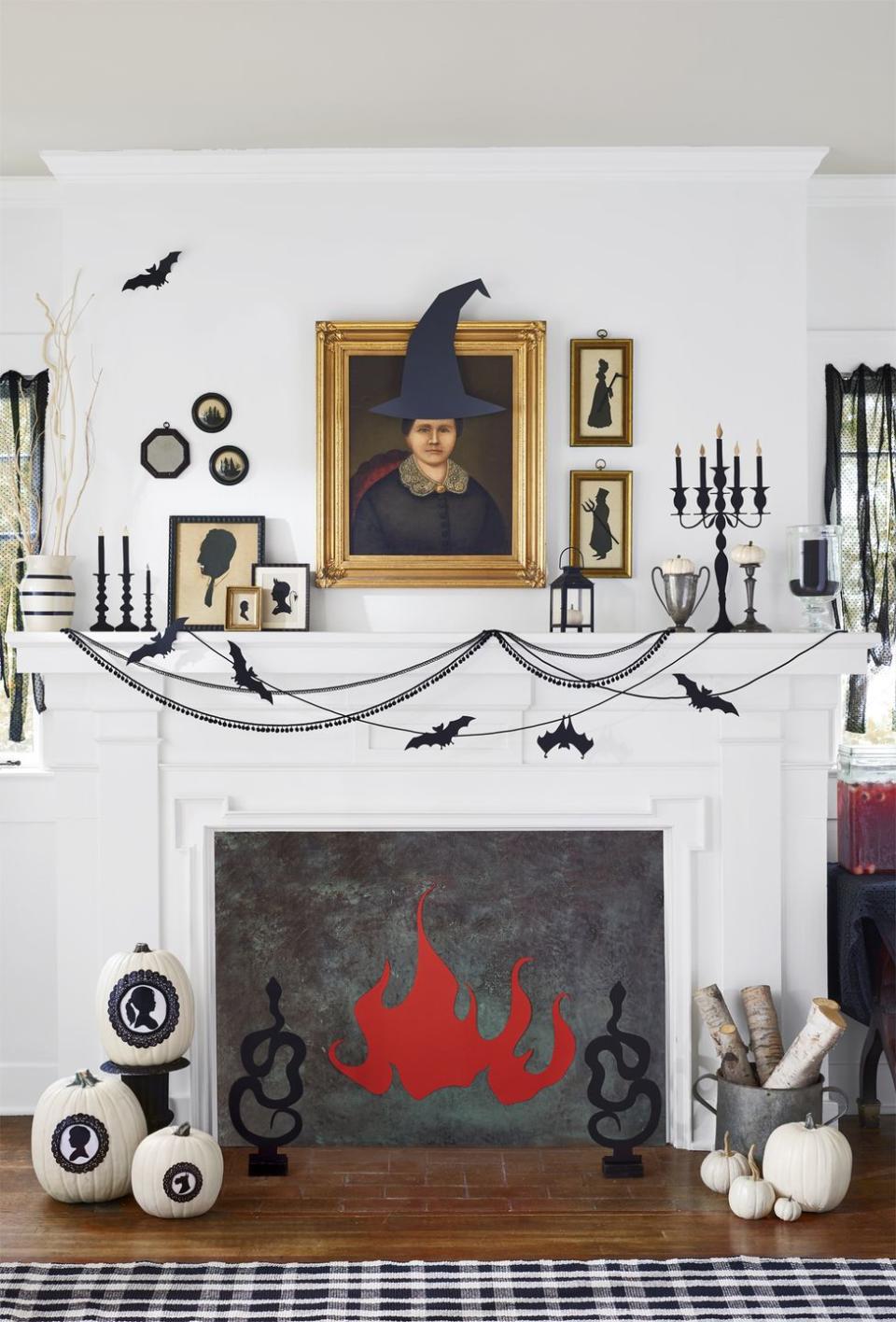 <p>To get this spooky look, adorn old portraits and silhouettes with witch hats, pitchforks and scythes, fangs, and devil horns. Detailed cutouts of candelabras and sticks, "lit" with gold flames, give this mantel a faux glow. Add paper bats attached to swoops of black sewing trimming with black upholstery tacks. Finally, line the opening of your fireplace with paper or painted wood, and attach a roaring red paper glow. Cut snake andirons from black foam core and glue to painted craft blocks. </p>