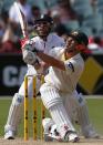 Australia's David Warner (front) plays a shot next to England's Matt Prior during the third day's play in the second Ashes cricket test at the Adelaide Oval December 7, 2013.