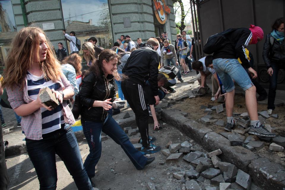 Ukrainian government supporters dig for stones during a clash with pro-Russians in the Black Sea port of Odessa, Ukraine, Friday, May 2, 2014. A clash broke out late Friday between pro-Russians and government supporters in Odessa, on the Black Sea coast some 550 kilometers (330 miles) from the turmoil in the east. Odessa had remained largely untroubled by unrest since the February toppling of pro-Russia President Viktor Yanukovych, which ignited tensions in the east. (AP Photo/Sergei Poliakov)