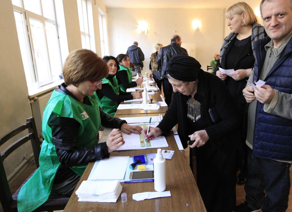 Voters lineup to get their ballots at a polling station during the presidential election at the polling station in Tbilisi, Georgia, Sunday, Oct. 28, 2018 . Voters in Georgia are choosing a new president for the former Soviet republic, the last time the president will be elected by direct ballot. (AP Photo/Shakh Aivazov)
